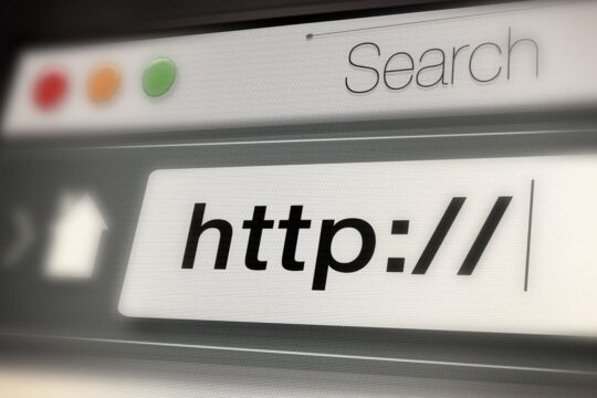 A imagem mostra uma captura de tela ampliada de uma barra de URL em um navegador de internet. A barra contém o texto "http://", sugerindo o início de um endereço de site. No canto superior esquerdo, há ícones de navegação, e ao lado da barra de URL, há a palavra "Search" (Busca). A estética remete a uma interface de navegação na web, representando o acesso a páginas e o início de uma pesquisa online.